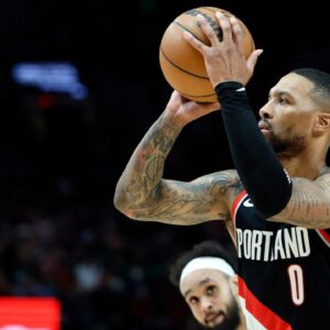 Portland Trail Blazers point guard Damian Lillard (0) shoots the ball as Portland Trail Blazers small forward Jerami Grant (9, behind) looks on during the first half at Moda Center