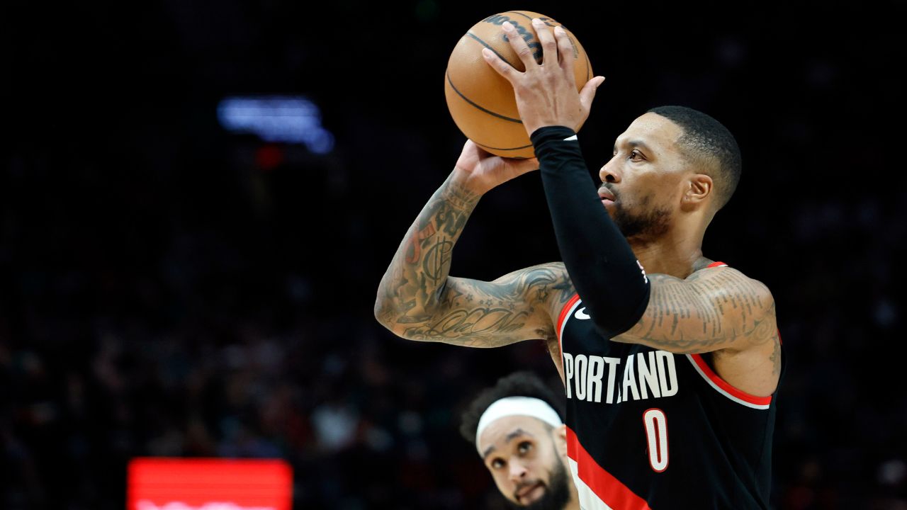 Portland Trail Blazers point guard Damian Lillard (0) shoots the ball as Portland Trail Blazers small forward Jerami Grant (9, behind) looks on during the first half at Moda Center