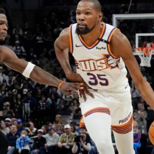 Phoenix Suns forward Kevin Durant (35) brings the ball up as Minnesota Timberwolves guard Anthony Edwards (5) defends him in the fourth quarter at Target Center.