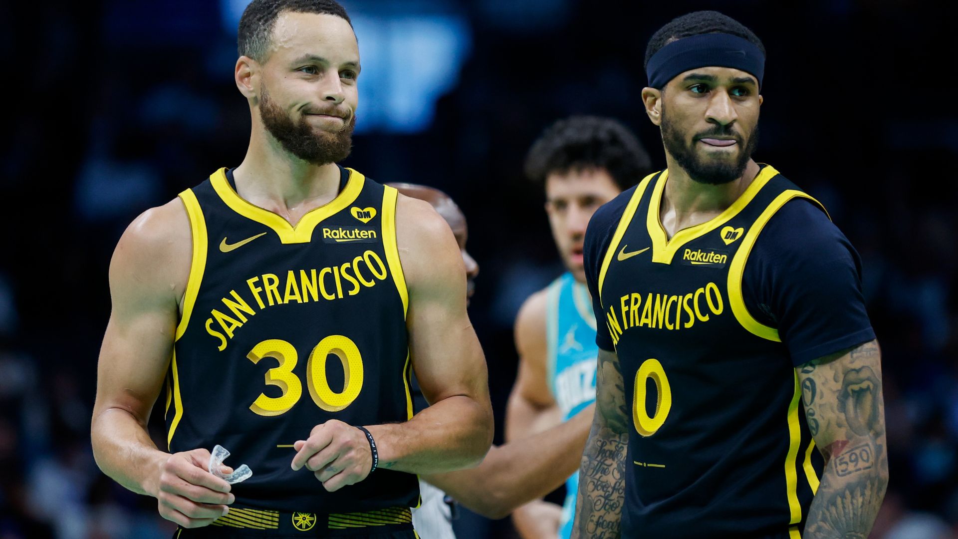 Mar 29, 2024; Charlotte, North Carolina, USA; Golden State Warriors guards Stephen Curry (30) and Gary Payton II look to the bench during a break in the action against the Charlotte Hornets during the first quarter at Spectrum Center.