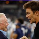 Dallas Cowboys owner Jerry Jones (L) talks to former NFL player Tom Brady (R) before the game against the Las Vegas Raiders at AT&T Stadium.