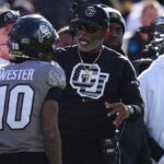 Colorado Buffaloes head coach Deion Sanders congratulates wide receiver LaJohntay Wester (10) for his punt return for a touchdown in the first quarter against the Utah Utes at Folsom Field.
