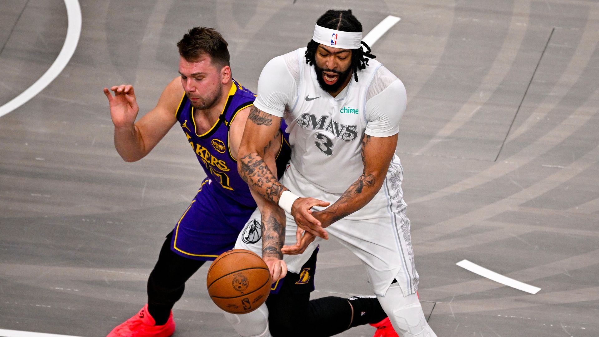 Apr 9, 2025; Dallas, Texas, USA; Los Angeles Lakers guard Luka Doncic (77) knocks the ball away from Dallas Mavericks forward Anthony Davis (3) during the first quarter at the American Airlines Center.
