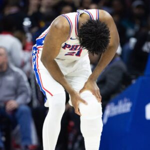 Philadelphia 76ers center Joel Embiid (21) holds his leg after a play against the Brooklyn Nets during the second quarter at Wells Fargo Center.