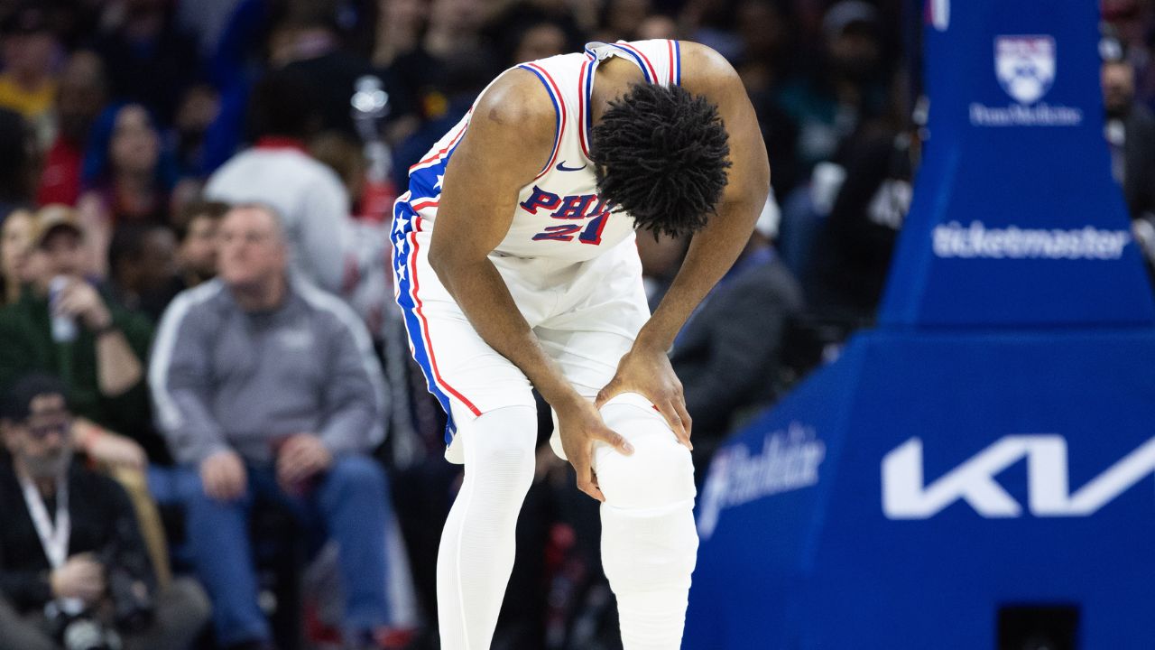 Philadelphia 76ers center Joel Embiid (21) holds his leg after a play against the Brooklyn Nets during the second quarter at Wells Fargo Center.
