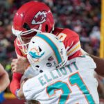 The helmet of Kansas City Chiefs quarterback Patrick Mahomes (15) cracks during his run as Miami Dolphins safety DeShon Elliott (21) makes contact in a 2024 AFC wild card game at GEHA Field at Arrowhead Stadium.