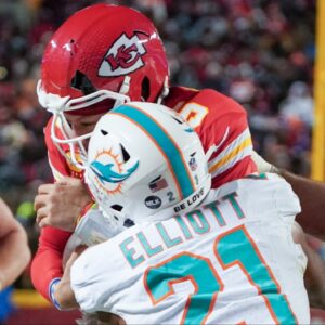 The helmet of Kansas City Chiefs quarterback Patrick Mahomes (15) cracks during his run as Miami Dolphins safety DeShon Elliott (21) makes contact in a 2024 AFC wild card game at GEHA Field at Arrowhead Stadium.