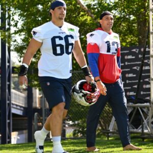 New England Patriots offensive tackle Will Campbell (66) and wide receiver Mack Hollins (13) walk to the practice fields for training camp at Gillette Stadium.