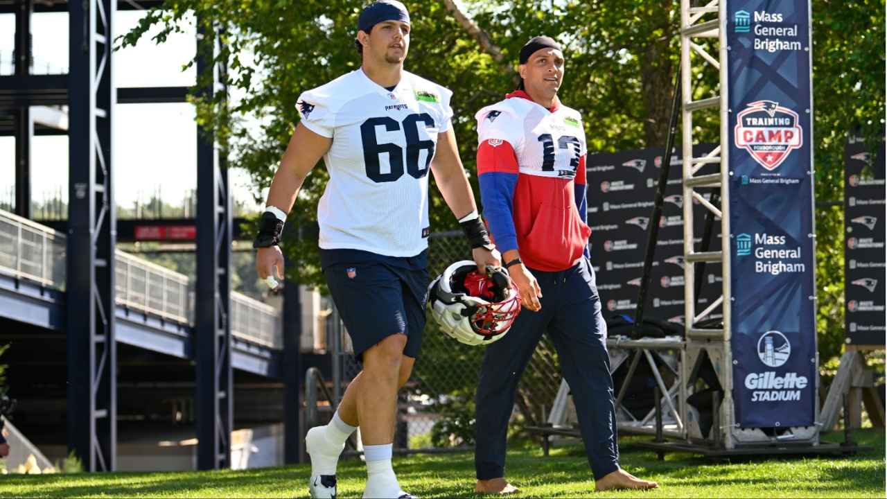 New England Patriots offensive tackle Will Campbell (66) and wide receiver Mack Hollins (13) walk to the practice fields for training camp at Gillette Stadium.