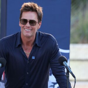 Retired New England Patriot Hall of Famer Tom Brady speaks during a statue unveiling before a game against the Washington Commanders at Gillette Stadium.