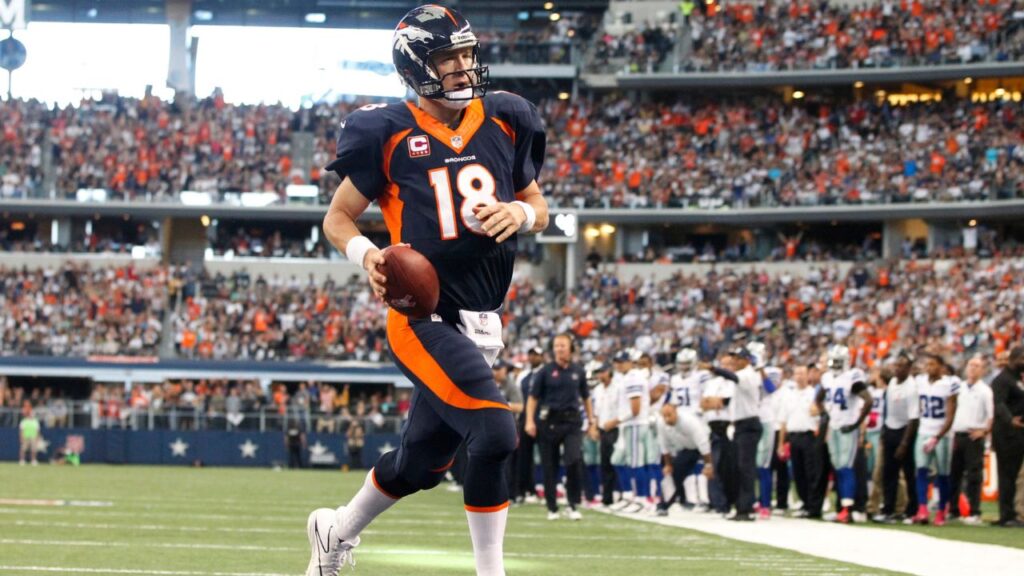 Broncos quarterback Peyton Manning (18) runs for a one yard touchdown in the second quarter against the Dallas Cowboys at AT&T Stadium.