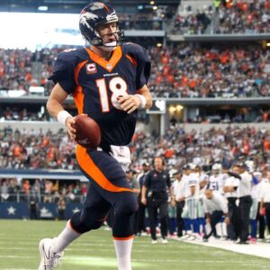 Broncos quarterback Peyton Manning (18) runs for a one yard touchdown in the second quarter against the Dallas Cowboys at AT&T Stadium.