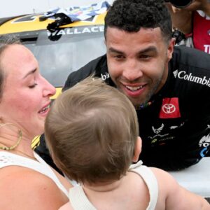 NASCAR Cup Series driver Bubba Wallace (23) embraces his wife, Amanda Carter, and child, Becks, on Sunday, July 27, 2025, after winning the Brickyard 400 at Indianapolis Motor Speedway.