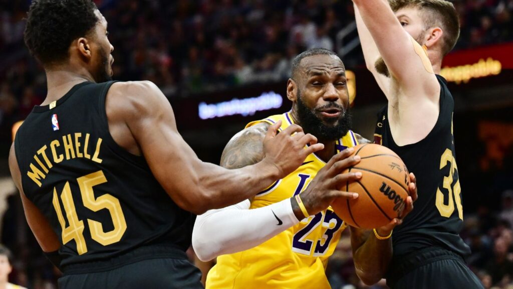 Los Angeles Lakers forward LeBron James (23) drives to the basket between Cleveland Cavaliers guard Donovan Mitchell (45) and forward Dean Wade (32) during the second half at Rocket Mortgage FieldHouse