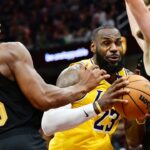 Los Angeles Lakers forward LeBron James (23) drives to the basket between Cleveland Cavaliers guard Donovan Mitchell (45) and forward Dean Wade (32) during the second half at Rocket Mortgage FieldHouse