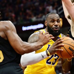 Los Angeles Lakers forward LeBron James (23) drives to the basket between Cleveland Cavaliers guard Donovan Mitchell (45) and forward Dean Wade (32) during the second half at Rocket Mortgage FieldHouse