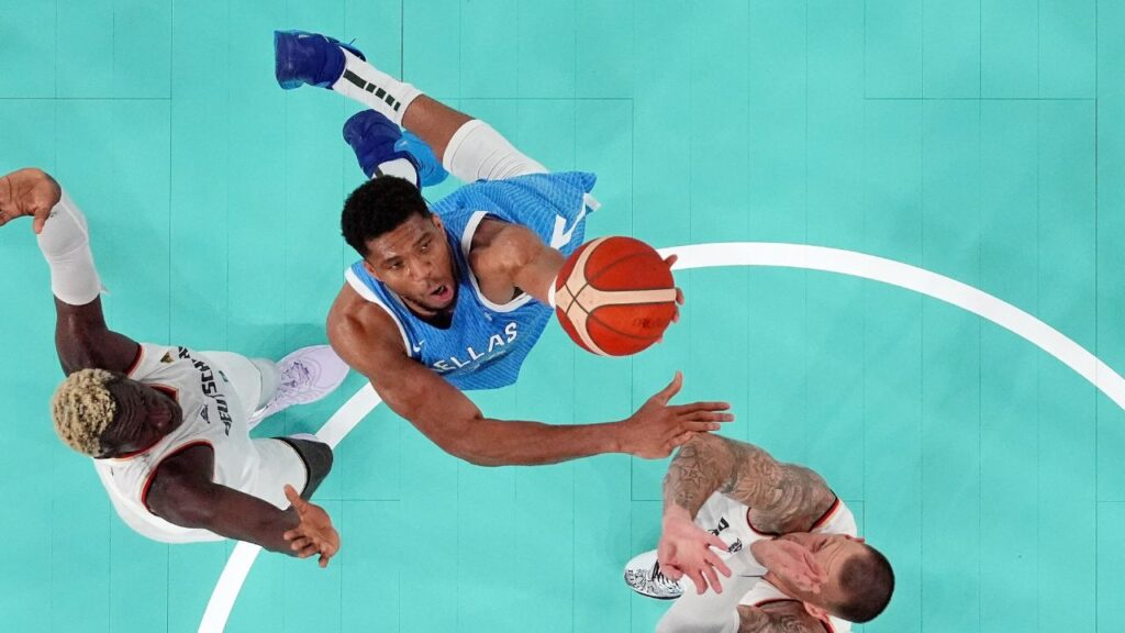 Greece small forward Giannis Antetokounmpo (34) shoots the ball against Germany point guard Isaac Bonga (left) and power forward Daniel Theis (right) during a menís basketball quarterfinal game during the Paris 2024 Olympic Summer Games at Accor Arena.