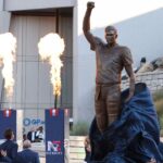 Retired New England Patriot Hall of Famer Tom Brady stands with Jonathan and Robert Kraft during a statue unveiling before a game against the Washington Commanders at Gillette Stadium.