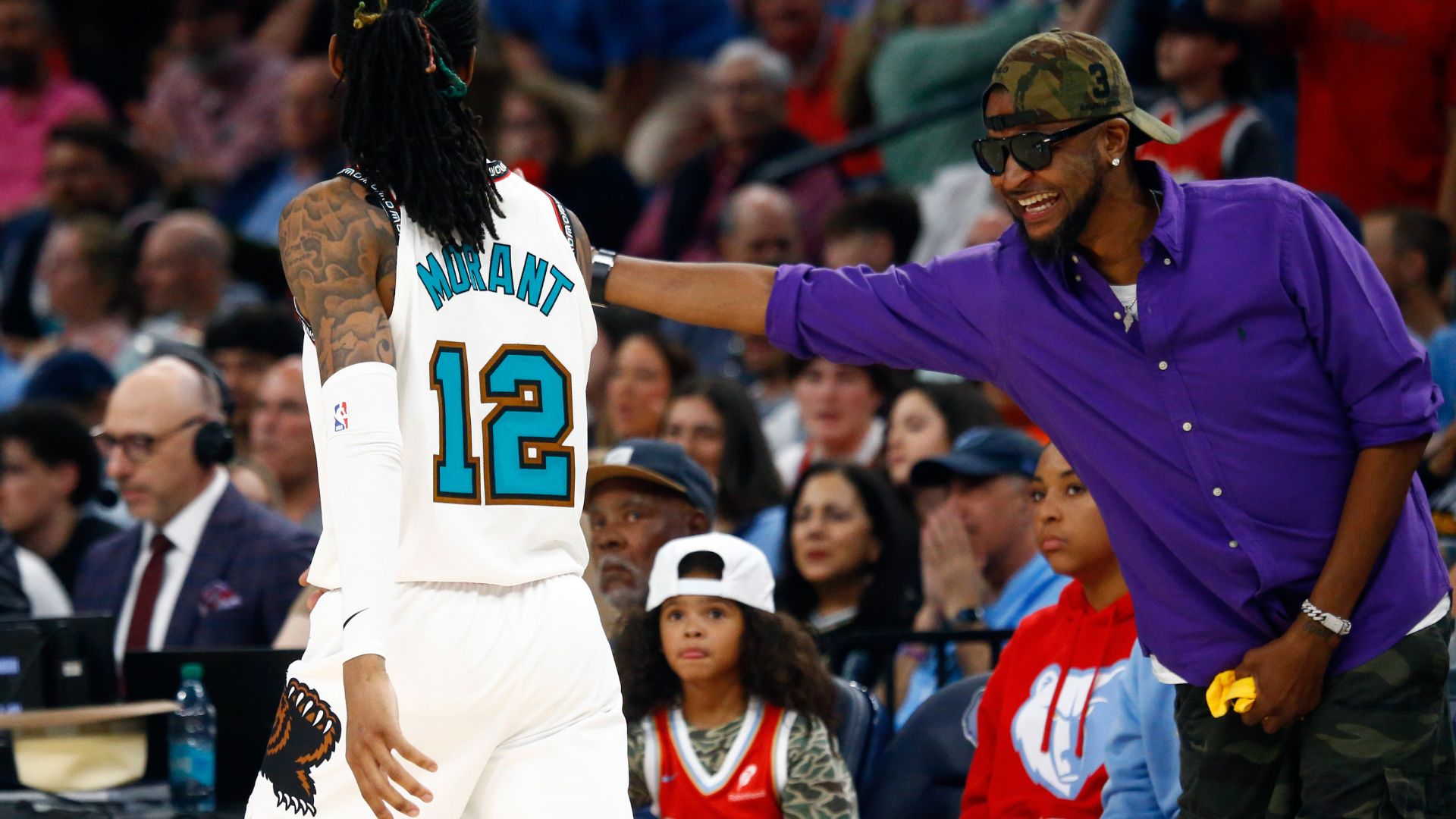 Apr 18, 2025; Memphis, Tennessee, USA; Memphis Grizzlies guard Ja Morant (12) reacts with his father, Tee Morant during the fourth quarter against the Dallas Mavericks at FedExForum.