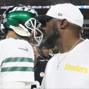 New York Jets quarterback Aaron Rodgers (8) and Pittsburgh Steelers head coach Mike Tomlin (right) greet each other after their game at Acrisure Stadium.