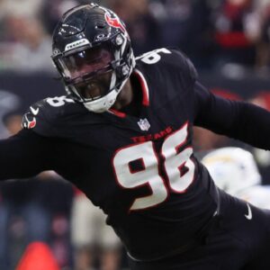 Jan 11, 2025; Houston, Texas, USA; Los Angeles Chargers quarterback Justin Herbert (10) is defended by Houston Texans defensive end Denico Autry (96) in the second quarter in an AFC wild card game at NRG Stadium.