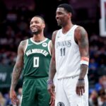 Mar 1, 2025; Dallas, Texas, USA; Dallas Mavericks guard Kyrie Irving (11) laughs with Milwaukee Bucks guard Damian Lillard (0) during the second half at American Airlines Center.