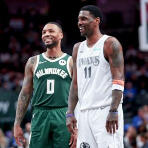 Mar 1, 2025; Dallas, Texas, USA; Dallas Mavericks guard Kyrie Irving (11) laughs with Milwaukee Bucks guard Damian Lillard (0) during the second half at American Airlines Center.