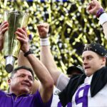 LSU Tigers head coach Ed Orgeron hoists the national championship trophy with quarterback Joe Burrow after a victory against the Clemson Tigers in the College Football Playoff national championship game at Mercedes-Benz Superdome.