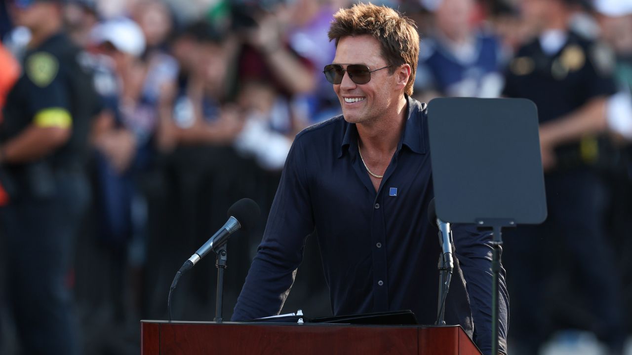 Retired New England Patriot Hall of Famer Tom Brady speaks during a statue unveiling before a game against the Washington Commanders at Gillette Stadium.