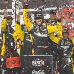 Ryan Blaney climbs out of his No. 12 Penske Ford in Victory Lane, Saturday night, Aug. 23, 2025, after winning the Coke Zero Sugar 400 at Daytona International Speedway.