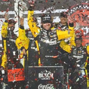 Ryan Blaney climbs out of his No. 12 Penske Ford in Victory Lane, Saturday night, Aug. 23, 2025, after winning the Coke Zero Sugar 400 at Daytona International Speedway.