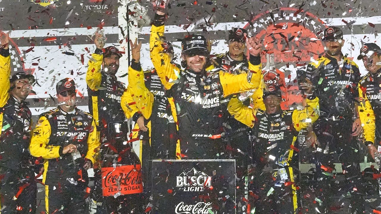 Ryan Blaney climbs out of his No. 12 Penske Ford in Victory Lane, Saturday night, Aug. 23, 2025, after winning the Coke Zero Sugar 400 at Daytona International Speedway.