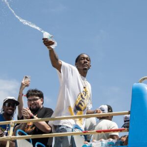 Oklahoma City Thunder player Jalen Williams splashes water on fans during the 2025 NBA Oklahoma City Thunder championship parade
