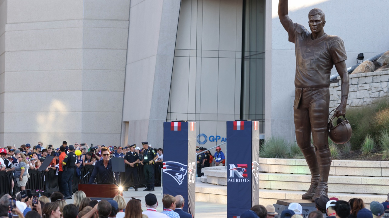 Retired New England Patriot Hall of Famer Tom Brady speaks during a statue unveiling before a game against the Washington Commanders at Gillette Stadium.