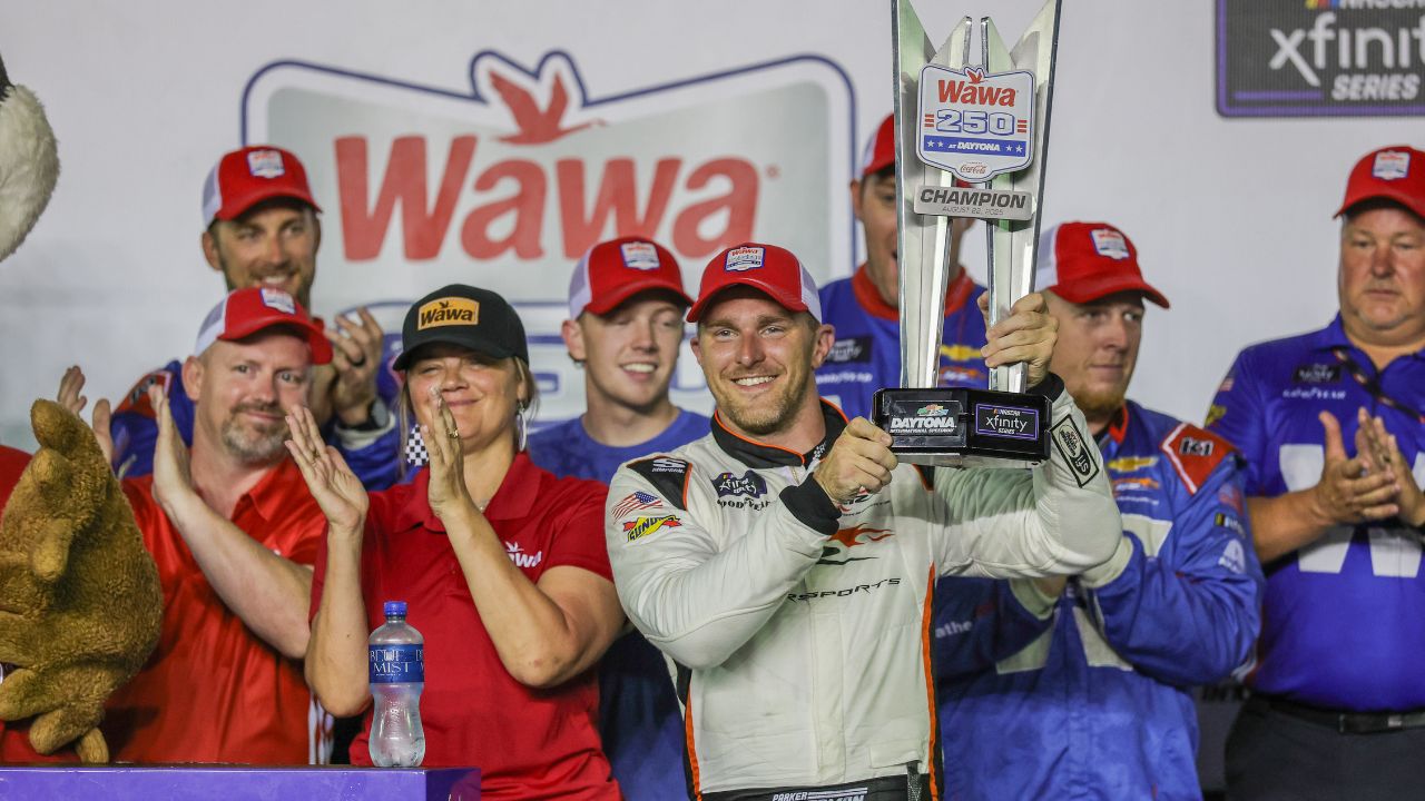 NASCAR Xfinity Series driver Parker Kligerman (88) holds the trophy in Victory Lane after winning the Wawa 250 at Daytona International Speedway.