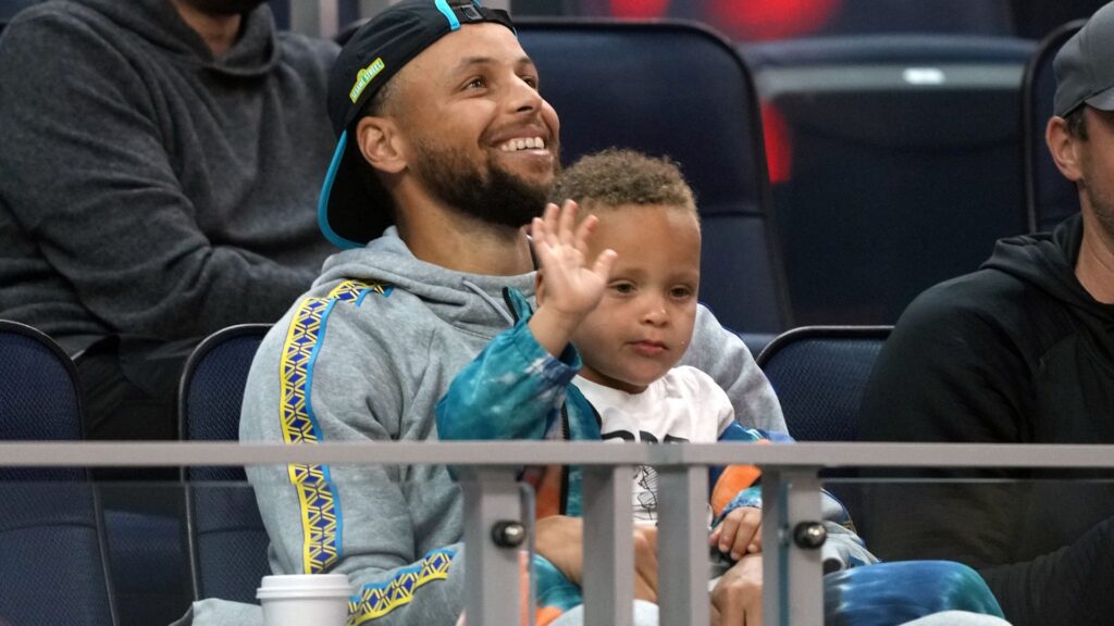 Jul 2, 2022; San Francisco, CA, USA; Golden State Warriors guard Stephen Curry (30) sits in the stands with son Canon during the second quarter against the Sacramento Kings at the California Summer League at Chase Center