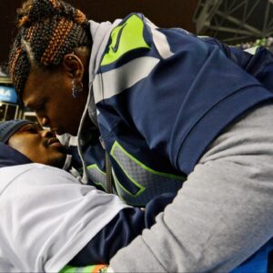 Seattle Seahawks running back Marshawn Lynch (left) kisses his mother Delisa Lynch (right) after the 2013 NFC Championship football game against the San Francisco 49ers at CenturyLink Field.