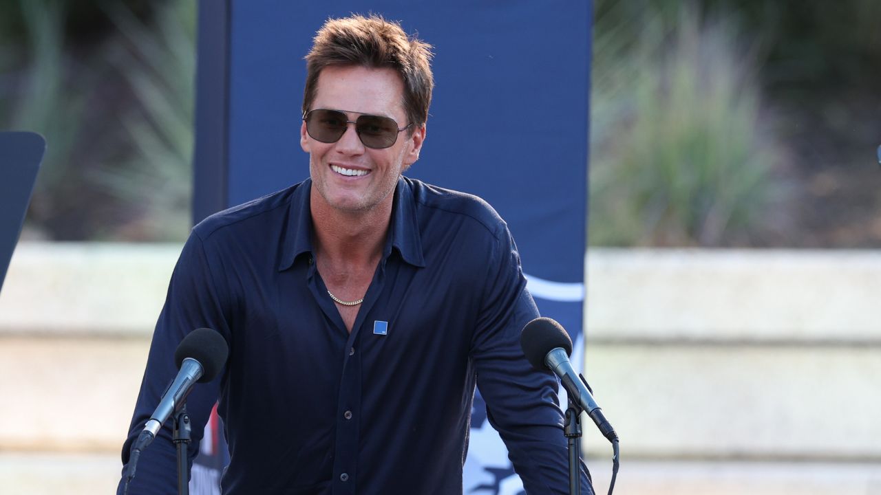 Retired New England Patriot Hall of Famer Tom Brady speaks during a statue unveiling before a game against the Washington Commanders at Gillette Stadium.
