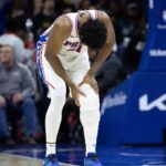 Philadelphia 76ers center Joel Embiid (21) holds his leg after a play against the Brooklyn Nets during the second quarter at Wells Fargo Center.