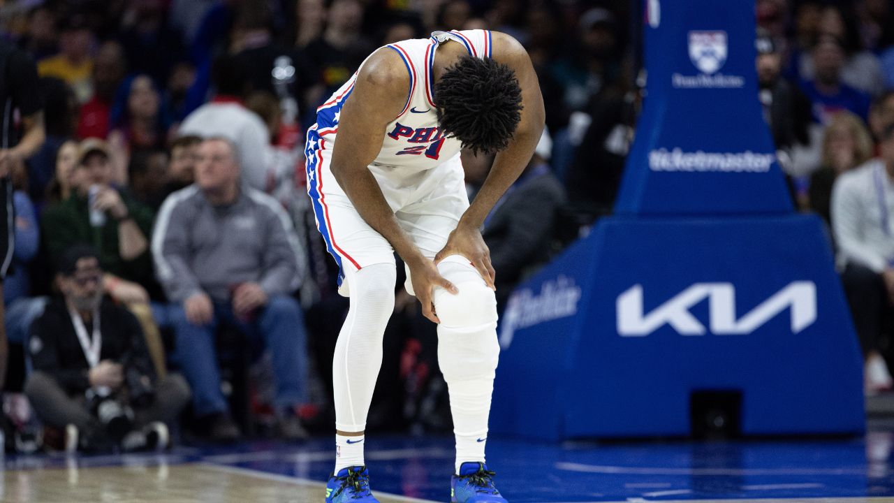 Philadelphia 76ers center Joel Embiid (21) holds his leg after a play against the Brooklyn Nets during the second quarter at Wells Fargo Center.