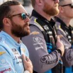 NASCAR Cup Series driver Ross Chastain stands with his team during the national anthem before the Cracker Barrel 400 at Nashville Superspeedway in Lebanon, Tenn., Sunday, June 1, 2025.