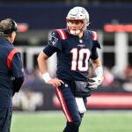 New England Patriots quarterback Mac Jones (10) talks with head coach Bill Belichick and Matthew Patricia during the second half of a game at Gillette Stadium.