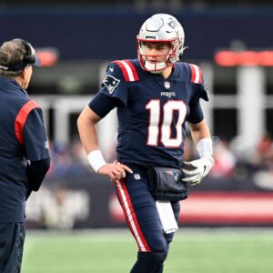 New England Patriots quarterback Mac Jones (10) talks with head coach Bill Belichick and Matthew Patricia during the second half of a game at Gillette Stadium.
