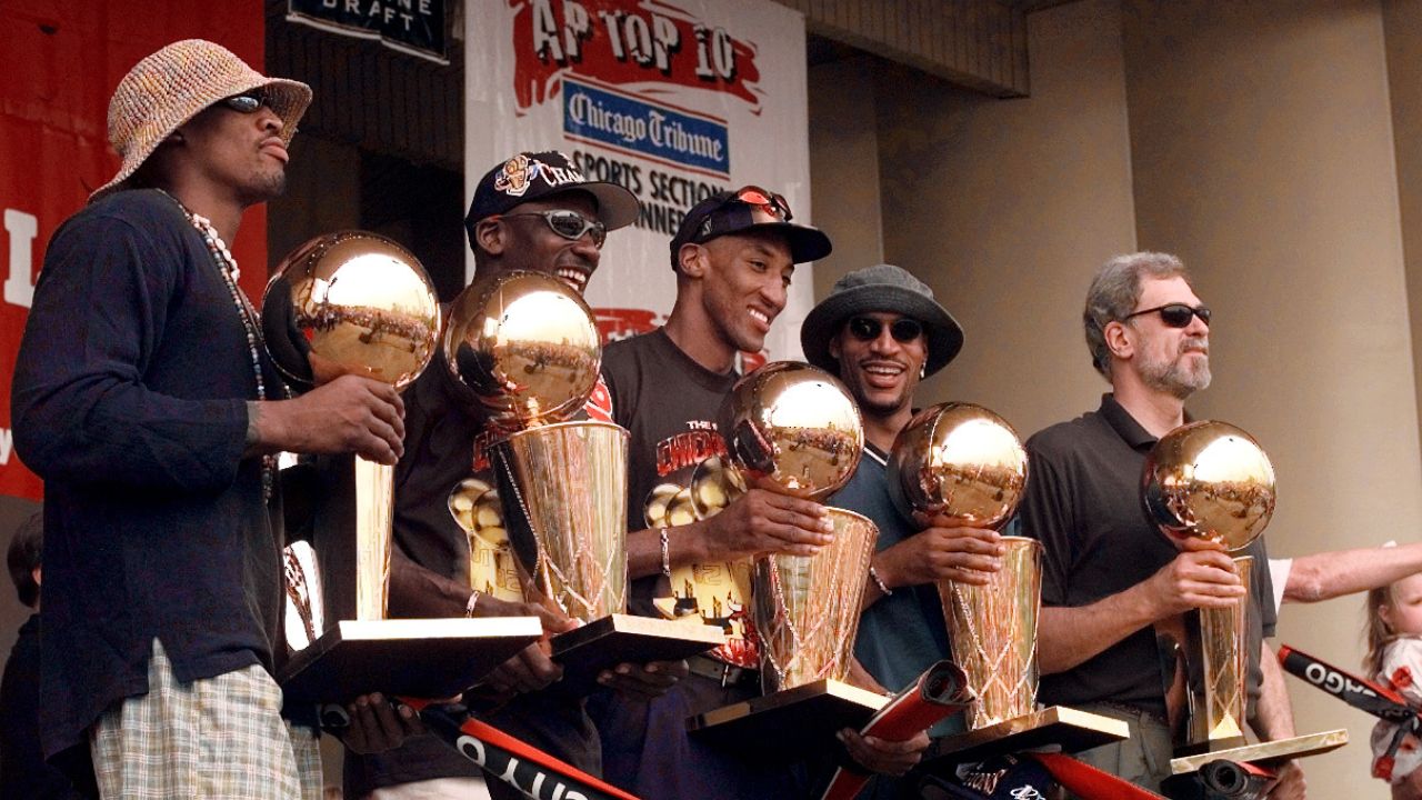 Jun 16, 1997; Chicago, IL, USA; Chicago Bulls players, left to right, Ron Harper, Dennis Rodman, Scottie Pippen, Michael Jordan & coach Phil Jackson hold up the Bulls' five championship trophies at a rally in Grant Park. Mandatory Credit: Anne Ryan-USA TODAY