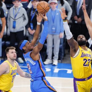 Oklahoma City Thunder guard Shai Gilgeous-Alexander (2) shoots as Los Angeles Lakers forward LeBron James (23) and center Jaxson Hayes (11) defend the shot during the first quarter at Paycom Center.