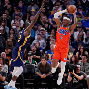 Apr 4, 2023; San Francisco, California, USA; Oklahoma City Thunder guard Shai Gilgeous-Alexander (2) passes the ball around the reach of Golden State Warriors forward Draymond Green (23) and guard Donte DiVincenzo (0) in the fourth quarter at the Chase Center.