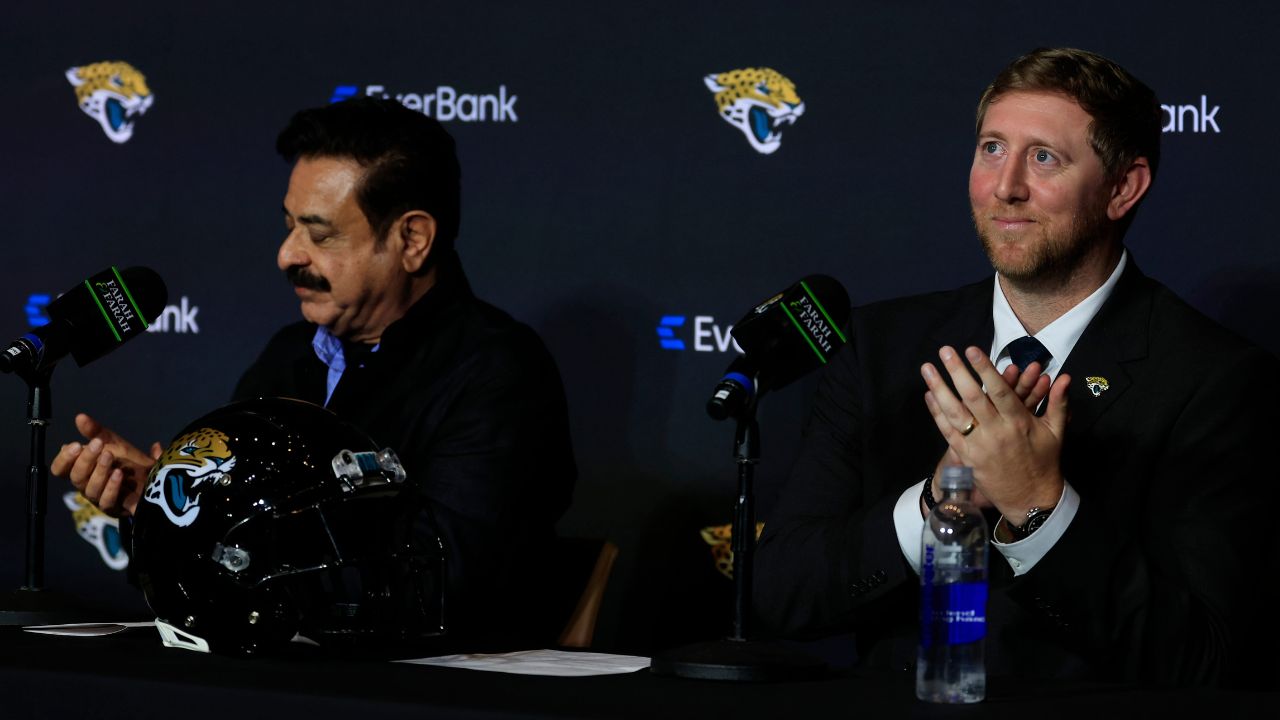 New Jacksonville Jaguars head coach Liam Coen, right, claps next to Jaguars owner Shad Khan after speaking and being introduced during a press conference.
