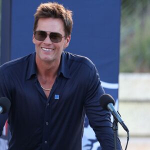 Retired New England Patriot Hall of Famer Tom Brady speaks during a statue unveiling before a game against the Washington Commanders at Gillette Stadium.