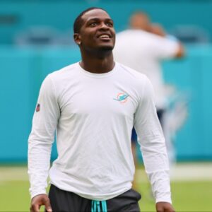 Miami Dolphins tight end Julian Hill (89), wide receiver Tyreek Hill (10), running back De'Von Achane (28), and wide receiver Jaylen Waddle (17) look on from the field before a preseason game against the Washington Commanders at Hard Rock Stadium.
