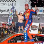 Aug 31, 2025; Darlington, South Carolina, USA; NASCAR Cup Series driver Chase Briscoe (19) and his son Brooks celebrates his win at the Cook Out Southern 500 at Darlington Raceway.